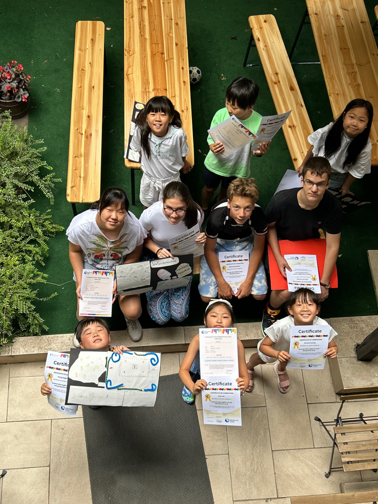 Children proudly hold certificates after completing an English summer course in Budapest.