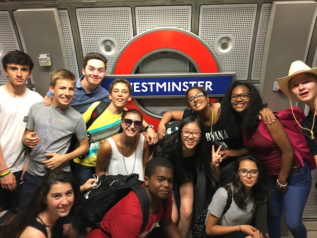 Young learners pose by the Westminster Underground sign during an English study trip in London